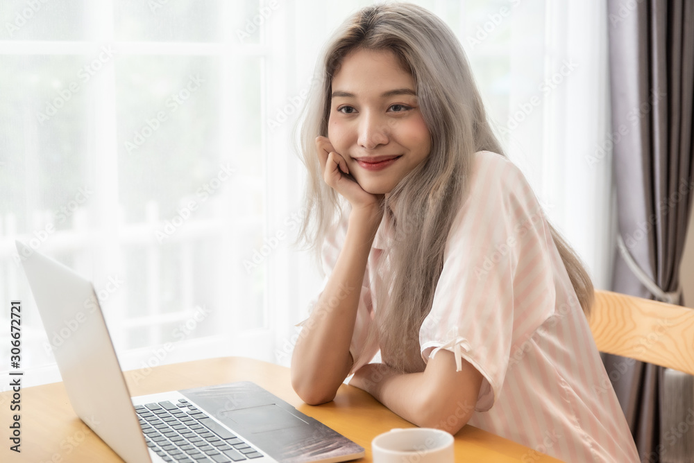 Lazy bored asian woman using laptop in the morning. Lazy bored asian woman using laptop in the morning.