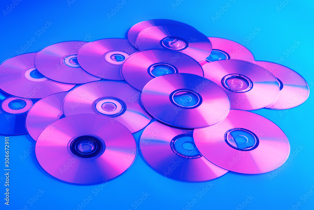 CDs on a plain background illuminated with neon light pink blue, minimal style