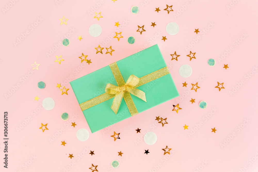 Gift or present box and stars confetti on a pink background. Colorful celebration, birthday, mother day background. Christmas or New Year pattern. Flat lay, top view Gift or present box and stars confetti on a pink background. Colorful celebration, birthday, mother day background. Christmas or New Year pattern. Flat lay, top view