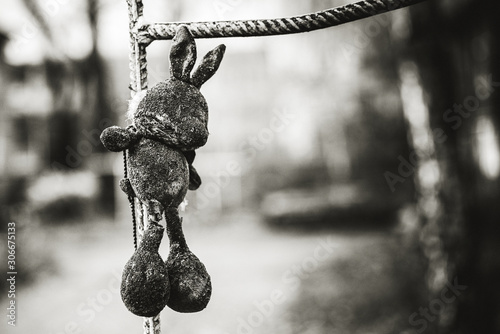 Torn old children toy plush rabbit, black and white, dramatic mood