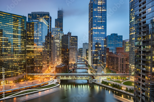 Chicago downtown skyline taken at Wolf Point in a fantastic cloudy evening, with lights of the skyscrapers reflected in the Chicago river, Illinois, United States photo