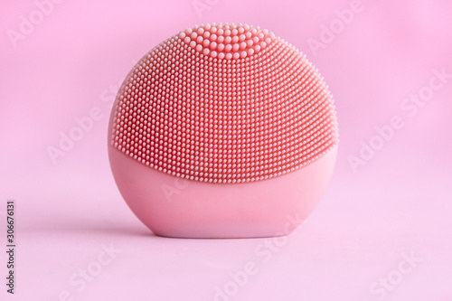 Silicone facial cleansing brushe with cleansing brush for massaging skin care on pink background. Product for face lifting, anti-aging wrinkles.