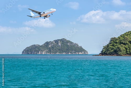 passenger airplane flying above small limestone island in tropical sea travel destinations concept