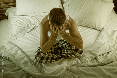 Fotografie dramatic lifestyle portrait of young attractive sad and depressed man sitting on