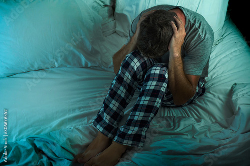 Obraz na plátně dramatic lifestyle portrait of young attractive sad and depressed man sitting on