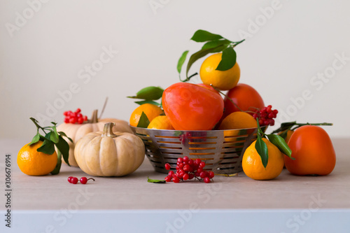 Food. Tangerines  viburnum  pumpkin  persimmon in table