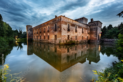 The castle of Padernello and his reflection in the water taken at dusk after the storm, Brescia province, Italy