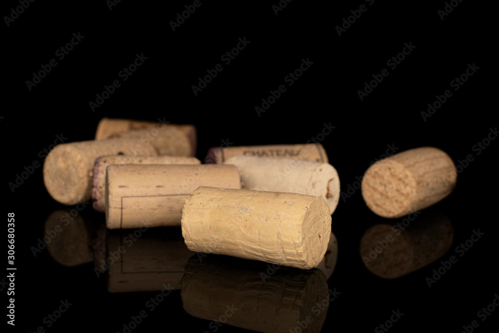 Lot of whole disordered common wine cork isolated on black glass