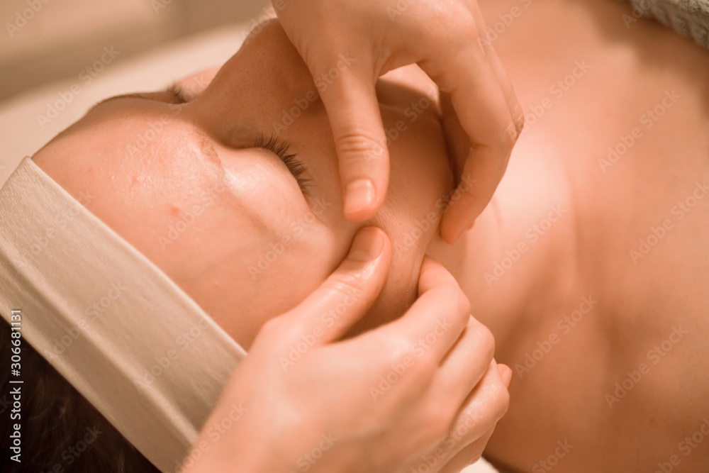 Beautiful plus size middle age woman getting a face massage treatment at beauty salon. close up step by step Beautiful plus size middle age woman getting a face massage treatment at beauty salon. close up step by step