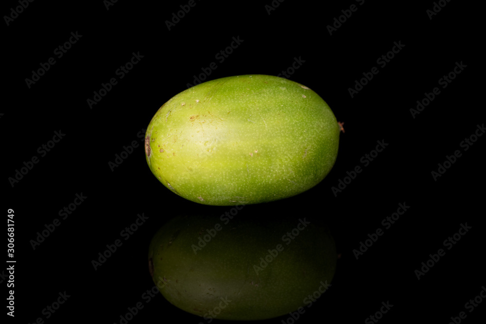 One whole hardy green kiwi isolated on black glass One whole hardy green kiwi isolated on black glass