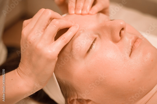 Beautiful plus size middle age woman getting a face massage treatment at beauty salon. close up step by step