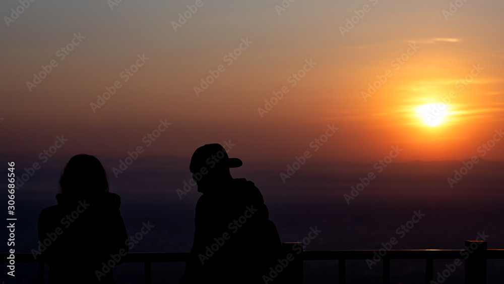 Silhouette of a couple  at sunrise with the sun in the background.