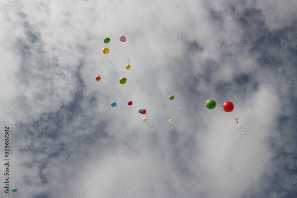 Background, texture, still life of multicolored balloons in the blue sky with white clouds. Background, texture, still life of multicolored balloons in the blue sky with white clouds.