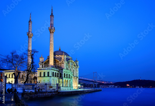 The Mecidiye Mosque in Ortakoy in the blue hour. In the background one of the bridges of Bosphorus, that connects the 2 sides of Istanbul, Turkey.