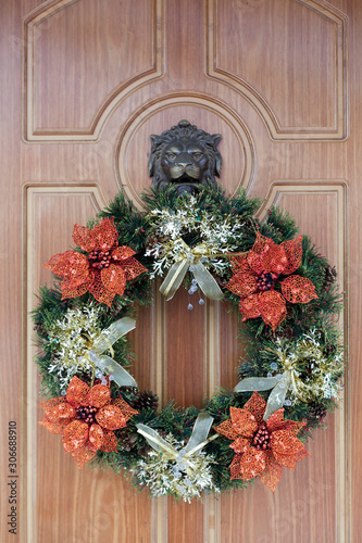 Christmas wreath with artificial Poinsettia on the front door for New Year, Christmas