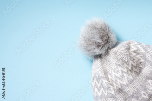 winter cloth gray hat on blue background with copy space. warm protection clothes