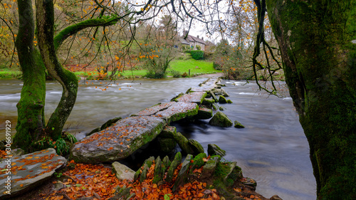 Autumn colours and a full flowing river Barle with the Tarr Steps, Exmoor photo