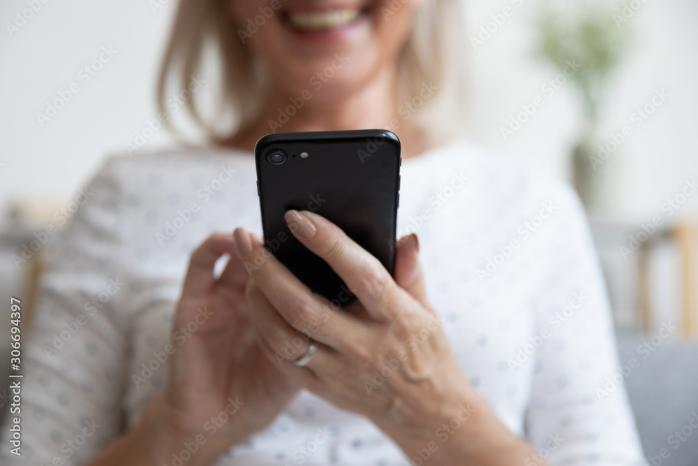 Elderly woman holding smartphone smiling enjoy online activity closeup view