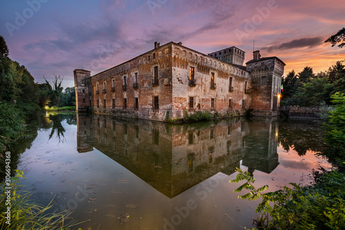 The castle of Padernello and his reflection in the water taken at sunset after the storm, Brescia province, Italy