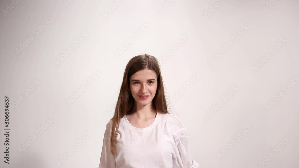 Girl in white t-shirt stretches and smile, white background Girl in white t-shirt stretches and smile, white background