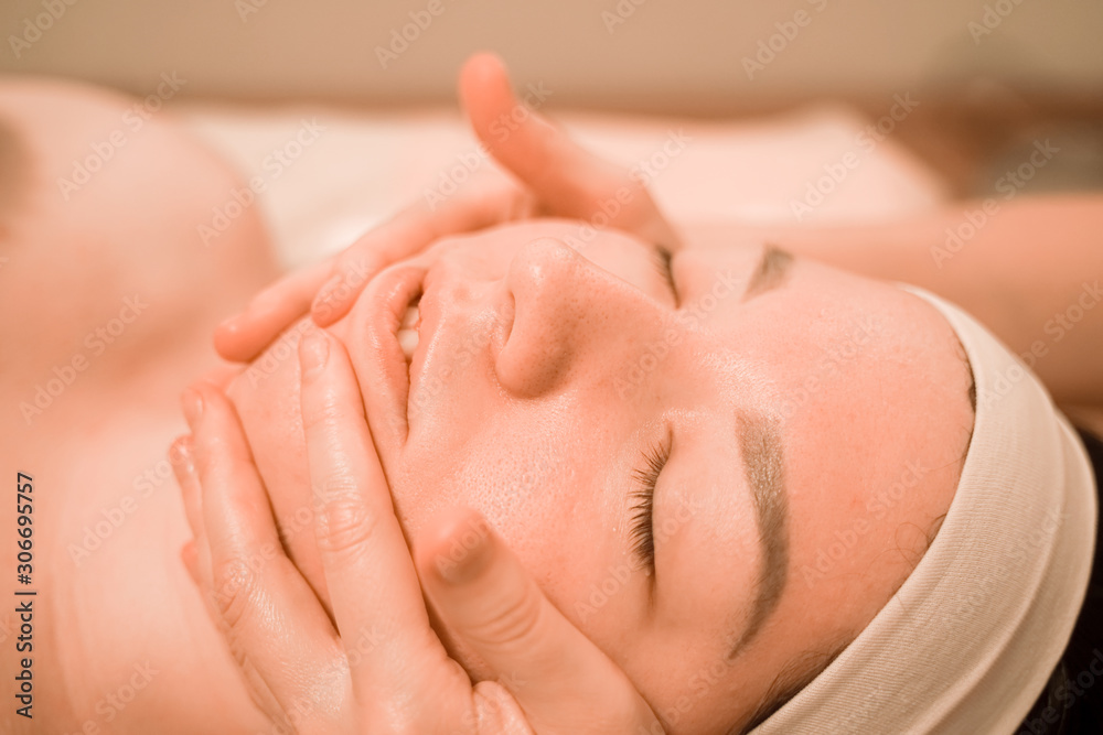 Beautiful young woman getting a face massage treatment at beauty salon Beautiful young woman getting a face massage treatment at beauty salon