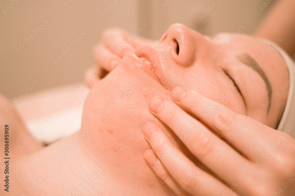 Beautiful young woman getting a face massage treatment at beauty salon Beautiful young woman getting a face massage treatment at beauty salon