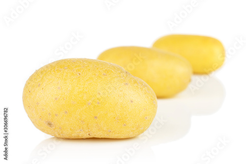 Group of three whole pale yellow potato placed diagonally isolated on white background