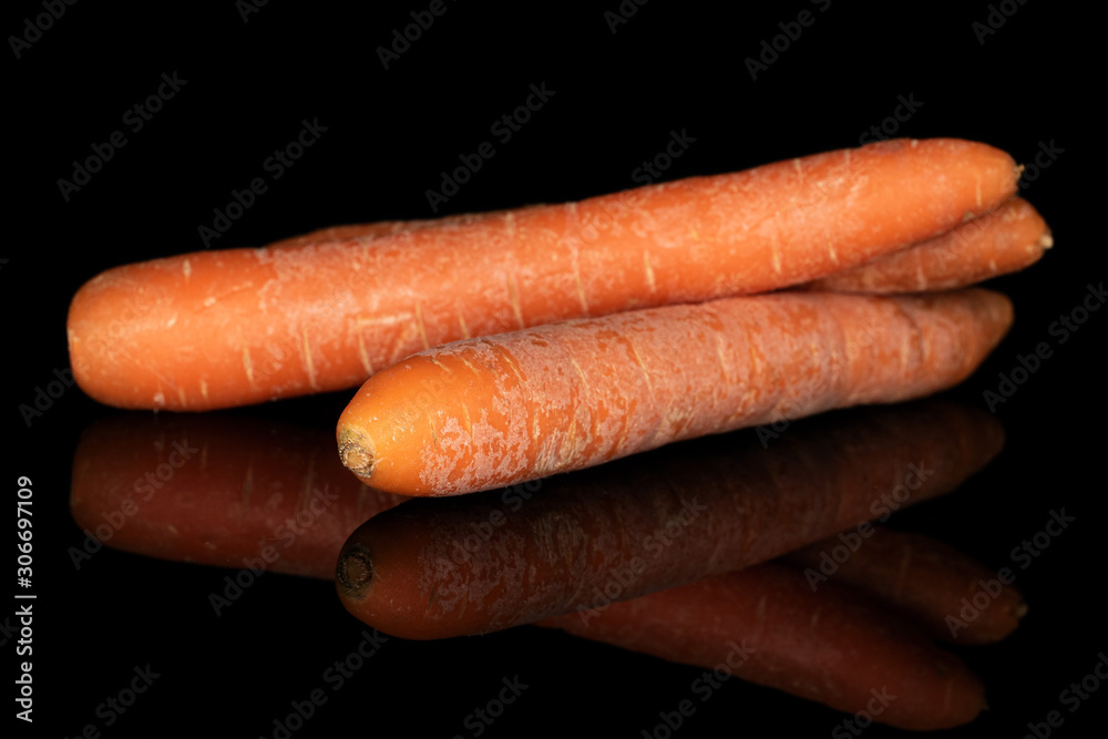 Group of three whole bright fresh orange carrot isolated on black glass Group of three whole bright fresh orange carrot isolated on black glass