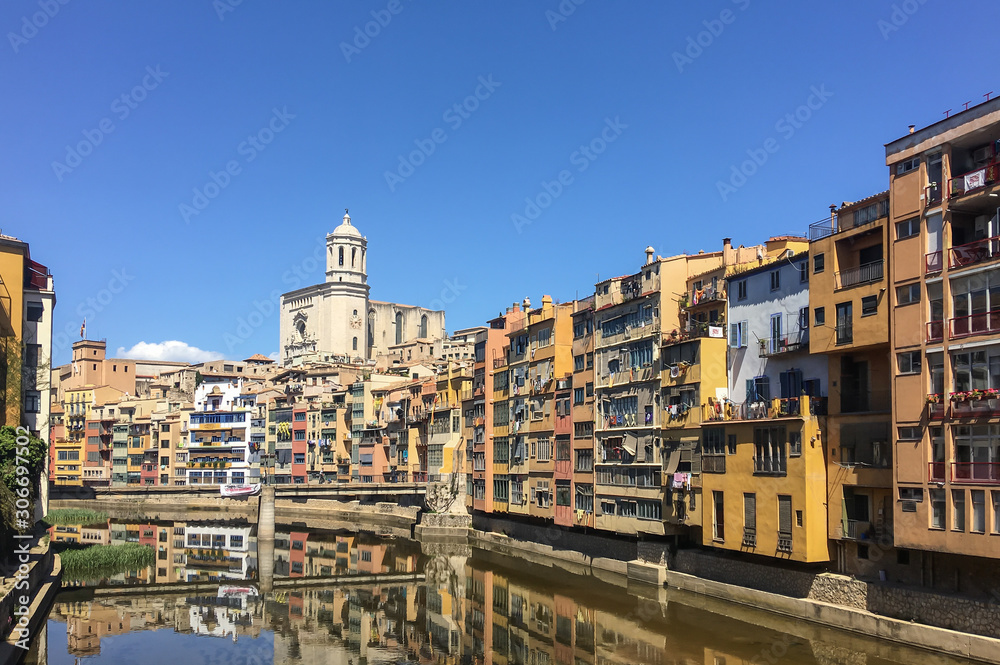 Buildings in residential district in Girona on bank of Onyar river with cathedral view 