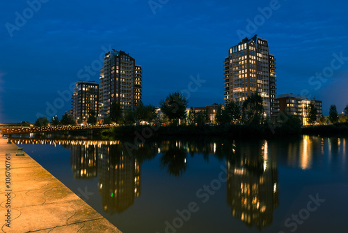 Reflections in water of skyline of quarter Oosterheem in city of Zoetermeer  Netherlands during blue hour