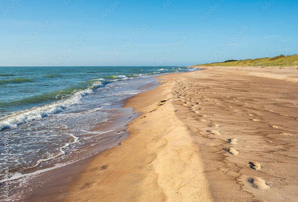 View on sandy wild beach with footprints in sand