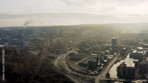 Aerial fly over Sheffield City during a winter sunrise showing the River Don and the skyscrapers in the developing city