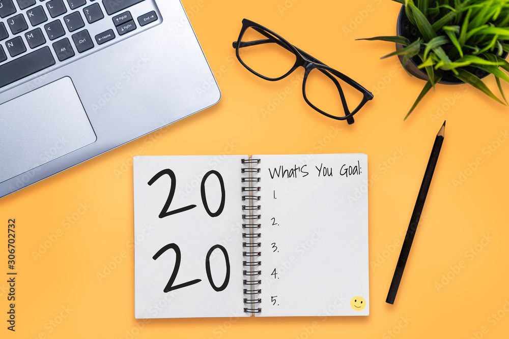 Plakat New Year Resolution Goal List 2020 - Business office desk with notebook written in handwriting about plan listing of new year goals and resolutions setting. Change and determination concept.