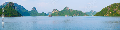 Panoramic view of Ha Long Bay unique limestone rock islands and karst formation peaks in the sea, famous tourism destination in Vietnam. Clear blue sky.