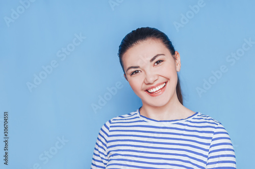 Smiling woman mouth with white healthy teeth on blue background.