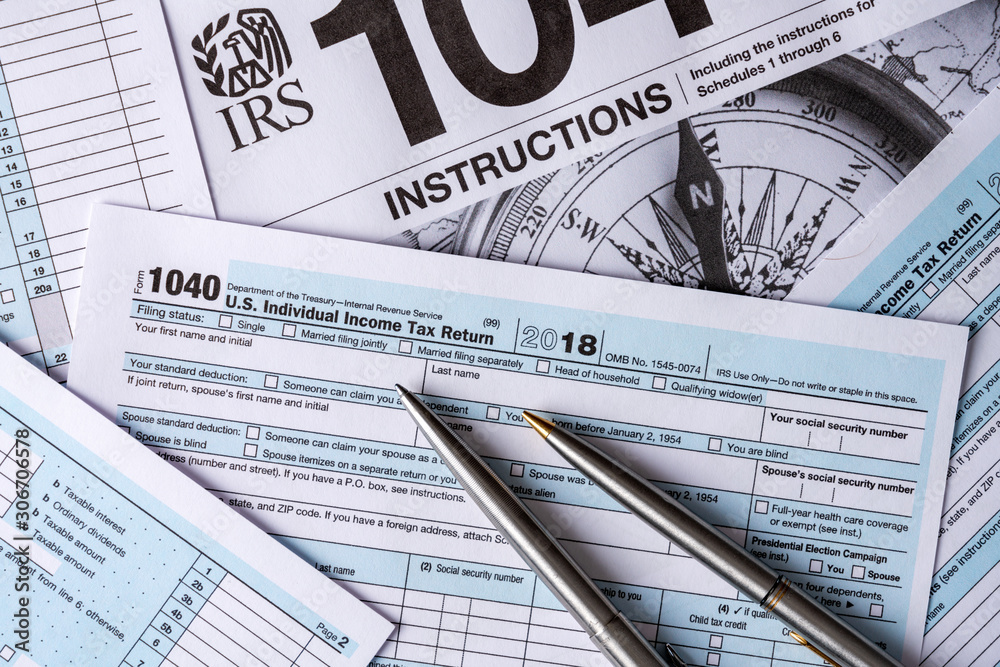 US individual income return 1040 tax forms on white background with pen US individual income return 1040 tax forms on white background with pen