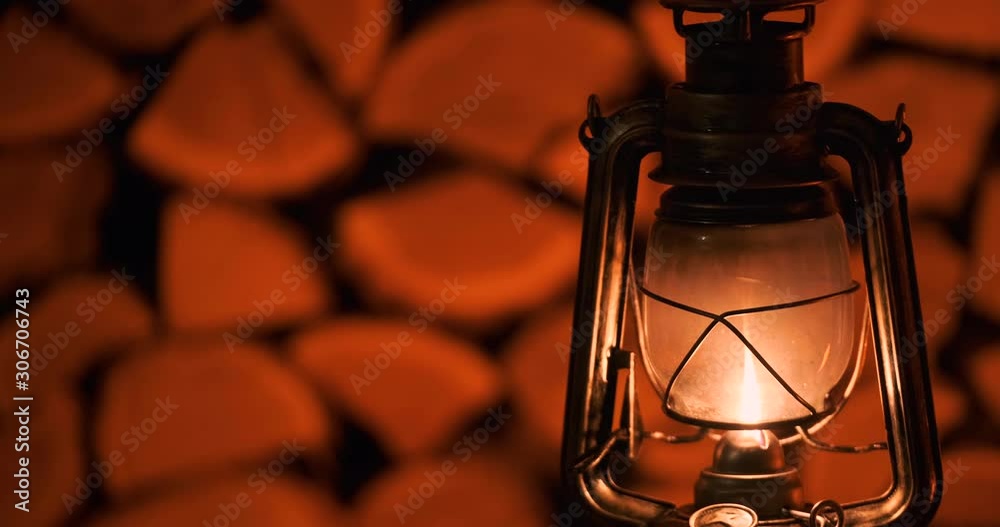 The antique oil lamp on a firewood background.