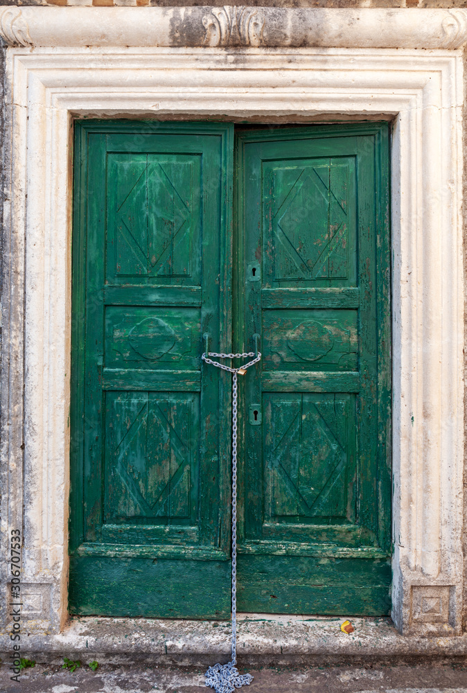 old wooden door in stone wall, background, Perast, Montenegro old wooden door in stone wall, background, Perast, Montenegro