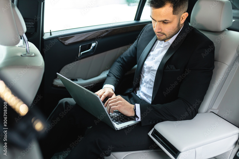 Young caucasian man with beard and dressed in formal wear sit with laptop and work, business people concept