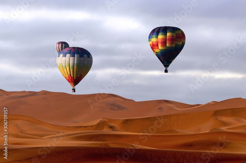 Beautiful Colorful Hot Air Balloons and dramatic clouds over the sand dunes in the Namib desert © Yuliia Lakeienko