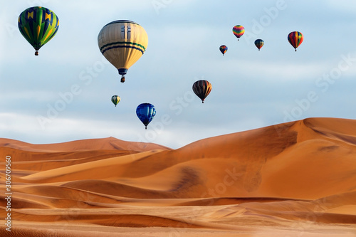 Beautiful Colorful Hot Air Balloons and dramatic clouds over the sand dunes in the Namib desert © Yuliia Lakeienko