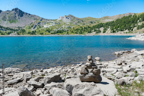 Lac d'Allos, parc national du Mercantour dans les Alpes de Haute Provence, France, tas de pierre empaillé empilé qui fait office de recueil pour personne disparu dans le lac il y a dix ans  photo