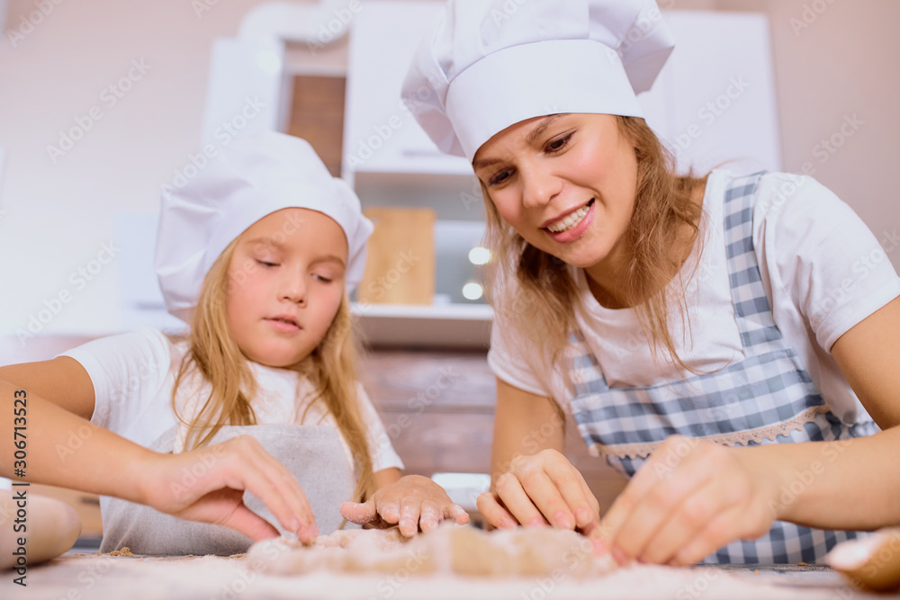making tasty delicious cake by little girl and caucasian woman, baking together at home making tasty delicious cake by little girl and caucasian woman, baking together at home