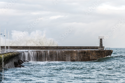 dangerous waves hiting a breakwater 