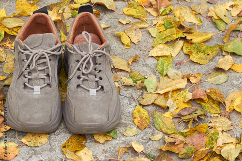 Sadness mood with the arrival of autumn, shoes on the background of fallen leaves. The concept of the arrival of autumn.