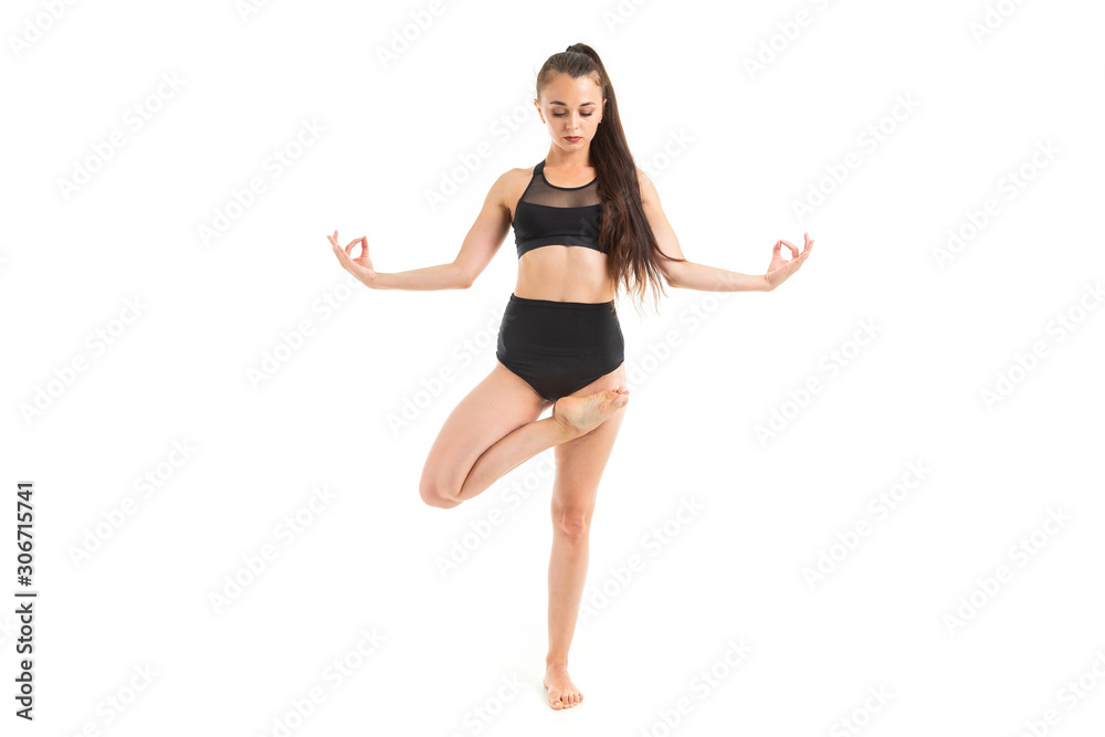 girl is concentrated on yoga in a black sports swimsuit on a white background