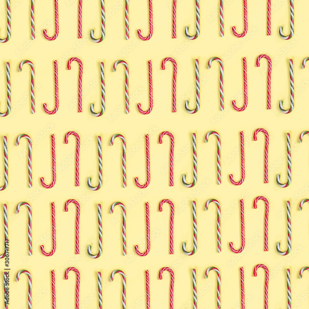 Concept Christmas pattern of candys laid on a yellow background.