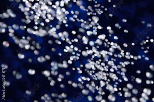 Abstract bokeh falling snow on a dark blue background winter motive