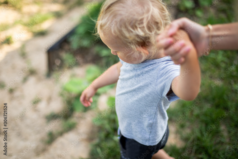 Parent holds hand of small child while walk outdoor Parent holds hand of small child while walk outdoor