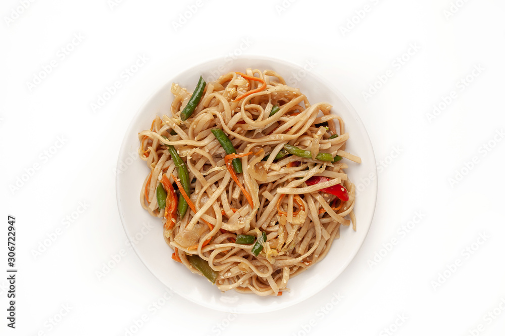 Asian vegetarian food udon noodles with Beijing cabbage, carrots, green beans, sweet pepper, onions on a plate on a white background Asian vegetarian food udon noodles with Beijing cabbage, carrots, green beans, sweet pepper, onions on a plate on a white background